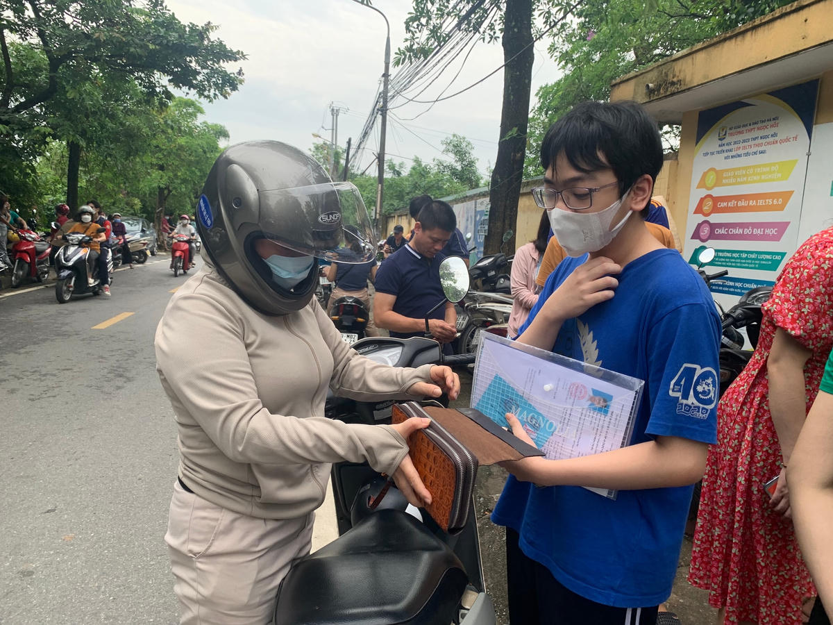 Phụ huynh dặn dò con kiểm tra giấy tờ trước khi vào trường thi.