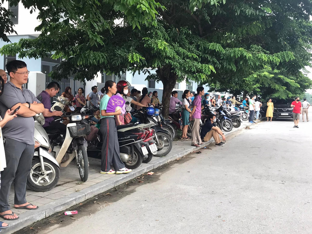 Rất đông phụ huynh đứng chờ con bên đường.