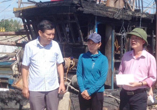 Ông Trần Quang Minh, Phó Chủ tịch Uỷ ban MTTQ tỉnh Quảng Bình (bên phải) đến thăm hỏi, động viên và trao hỗ trợ ngư dân ở xã Cảnh Dương có tàu cá bị cháy.