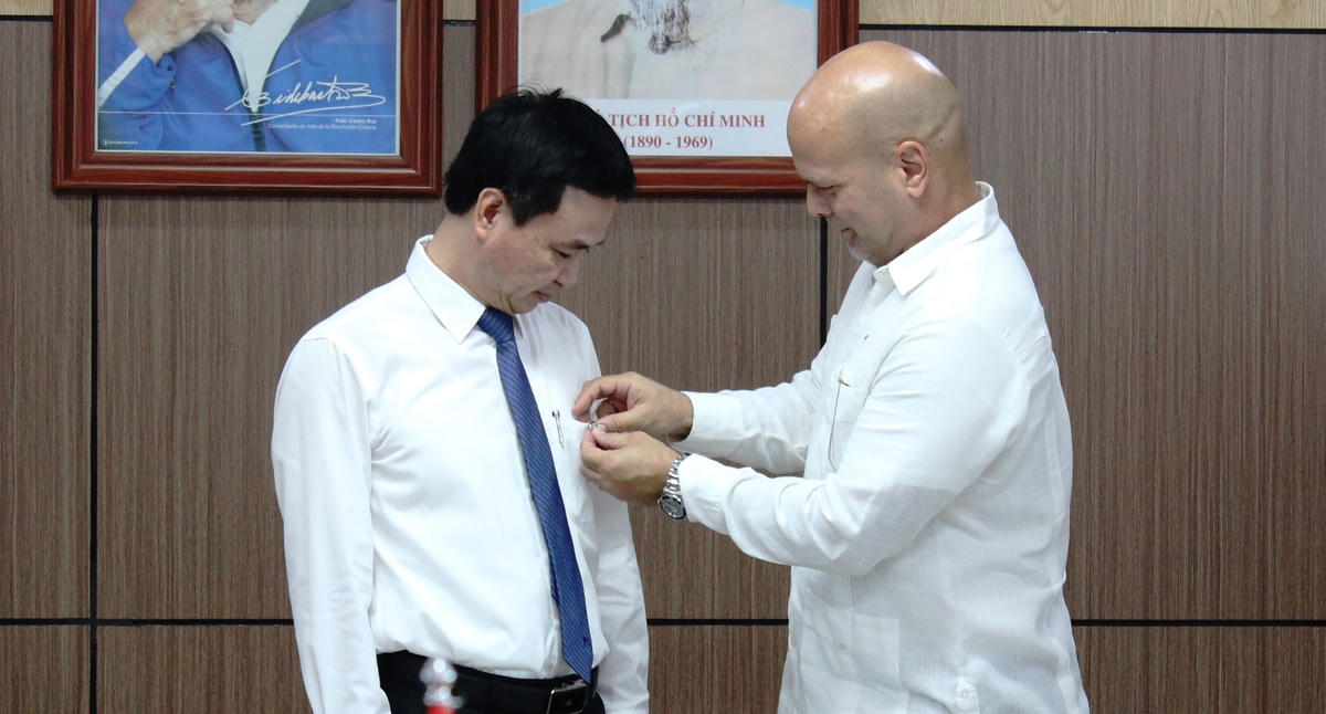 Ông Gerardo Hernandez Nordelo, Ủy viên Trung ương Đảng Cộng sản Cuba, Chủ tịch Ủy ban Bảo vệ Cách mạng Cuba tặng huy hiệu cho ông Nguyễn Đức Cường, Giám đốc Bệnh viện Hữu nghị Cuba - Đồng Hới.