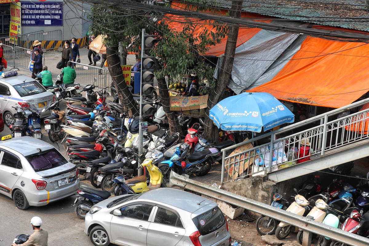 Phía dưới chân cầu bộ hành, hàng chục chiếc xe máy bủa vây chiếm hết lối đi bộ của người dân.