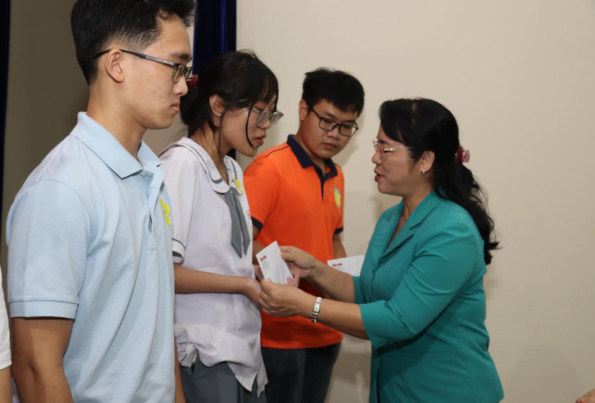Ông Trương Hòa Bình, bà Trần Kim Yến cùng các đại biểu trao học bổng cho các học sinh, sinh viên.  