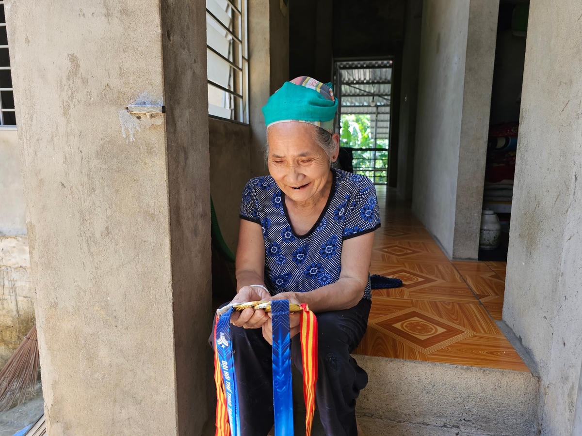 Bà Đỗ Thị Mạc ngắm nhìn những tấm huy chương mà Duyên dành tặng cho bà.