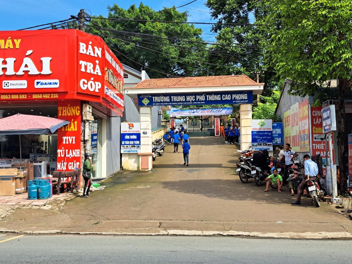 Tại điểm thi THPT Cao Phong thời tiết có phần hửng nắng, rất nhiều phụ huynh xếp hàng ngồi đợi phía ngoài cổng. Điểm thi này gồm 15 phòng thi với  336 thí sinh tham gia dự thi tốt nghiệp THPT 2023.