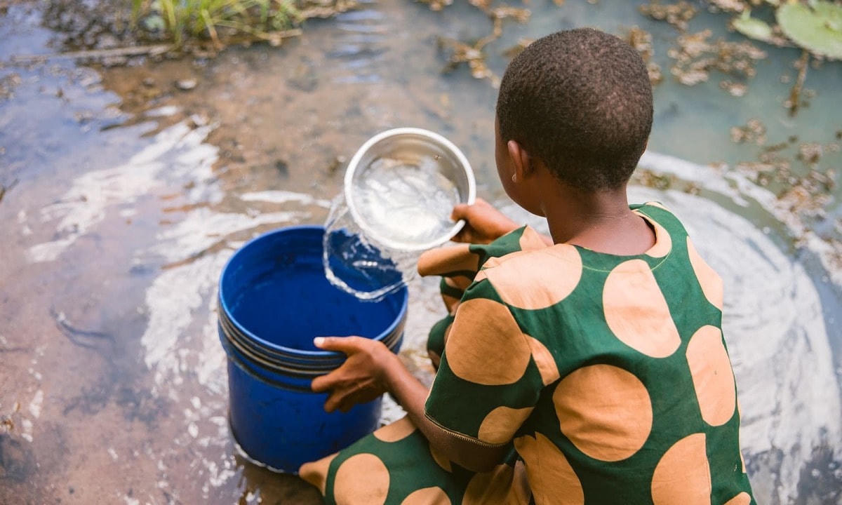 Em bé ở Tanzania đang lấy nước từ một cái ao. Nguồn: Lifewater.