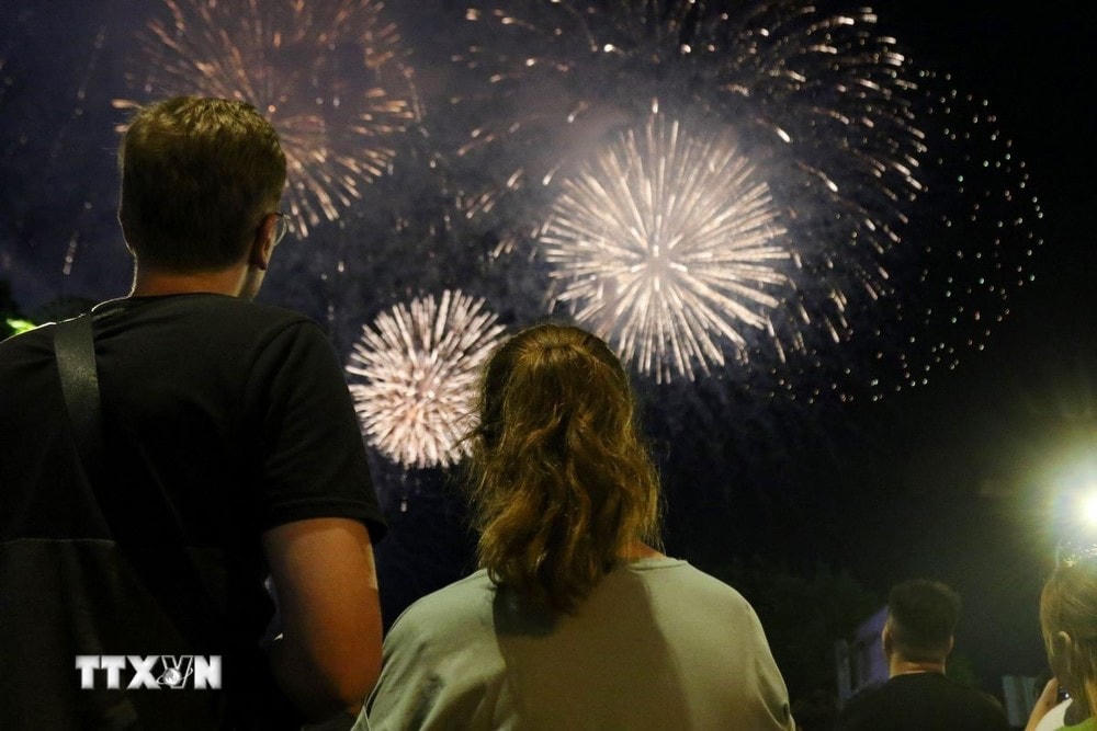 Người dân xem bắn pháo hoa tại khu vực công viên bến Bạch Đằng (1uận 1). (Ảnh: Thu Hương - TTXVN)