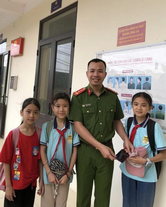 3 học sinh trao chiếc điện thoại nhặt được cho cán bộ Công an xã Tản Hồng.
