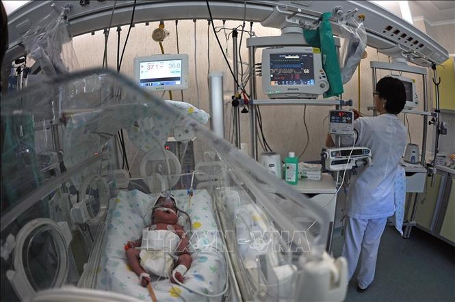 Nhân viên y tế chăm sóc bé sơ sinh tại bệnh viện ở Rome, Italy. Nguồn: AFP.