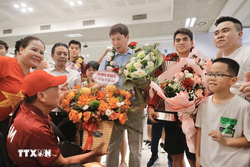 Người hâm mộ tặng hoa thầy trò huấn luyện viên Kim Sang Sik. (Ảnh: Minh Quyết/TTXVN)