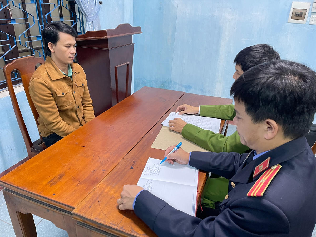 Đối tượng Trần Duy Pháp (bìa trái) tại cơ quan Công an.