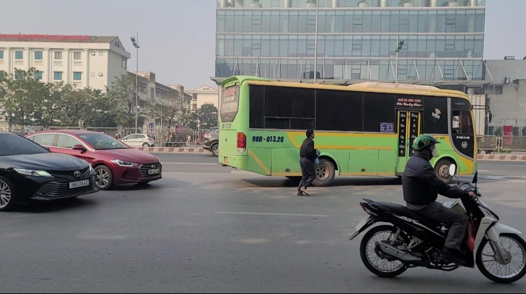 Nhà xe Năm Thủy đi Bắc Giang, Bắc Ninh BKS 01320 đón khách ngay đường Phạm Văn Đồng. Sở GTVT Hà Nội vừa đưa vào khai thác 41 điểm dừng đón, trả khách cho xe ô tô vận tải hành khách tuyến cố định trên địa bàn thành phố bao gồm các tuyến: QL6 (đoạn Hà Đông - Chương Mỹ); đường Hồ Chí Minh (đoạn Hoà Lạc - Xuân Mai); QL21 (đoạn Chốt Nghệ - Hoà Lạc); QL32 (đoạn Hoài Đức - Đan Phượng - Phúc Thọ - Sơn Tây - Ba Vì); đường Võ Văn Kiệt (đoạn cầu Thăng Long - QL2); QL3 (đoạn qua địa phận Hà Nội).Theo danh sách trên, dọc tuyến đường Phạm Văn Đồng, Phạm Hùng, Khuất Duy Tiến, Nguyễn Xiển, ngoài xe buýt, không có bất kỳ điểm đón, trả khách nào được cấp phép cho xe khách tuyến cố định. Các văn bản trước đây cũng đều khẳng định, xe vận tải hành khách tuyến cố định chỉ được đón, trả khách trong các bến xe. Đồng thời, như thường lệ, năm nào, lực lượng chức năng cũng “hứa hẹn” sẽ giải quyết dứt điểm tình trạng “xe dù, bến cóc”. Nhưng trên thực tế thì tình trạng dừng, đỗ xe, đón, trả khách không đúng nơi quy định vẫn diễn ra một cách ngang nhiên hàng ngày.