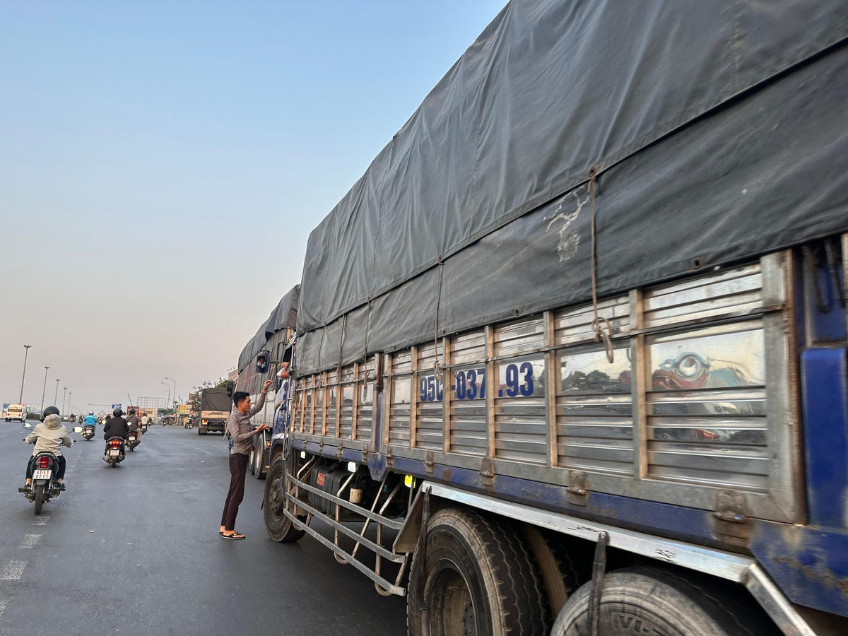 Một người đàn ông bán cơm trực tiếp cho tài xế ngay giữa quốc lộ. Ảnh: Mạnh Thìn.