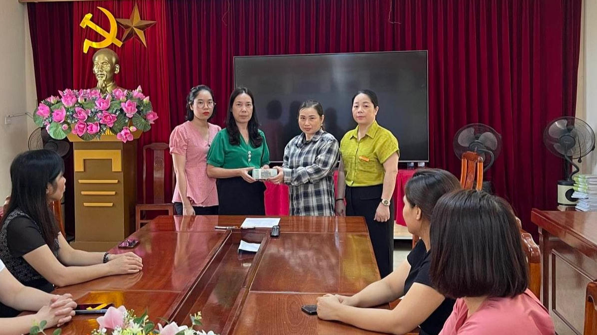 Cô Nguyễn Thị Hồng - Hiệu trưởng Trường Tiểu học Yên Sở trao tiền ủng hộ cho mẹ học sinh Lê Thu Quỳnh.