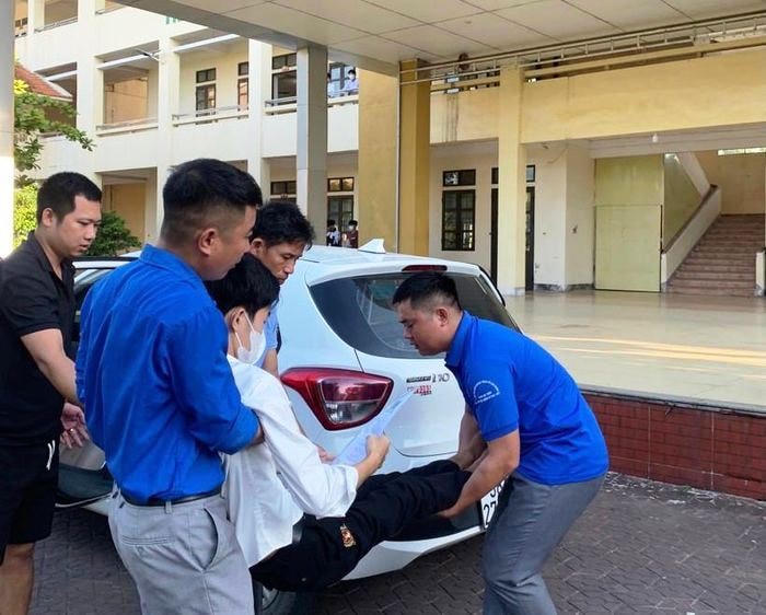 Thí sinh Nguyễn Tấn Tài được thanh niên tình nguyện bế lên phòng thi.
