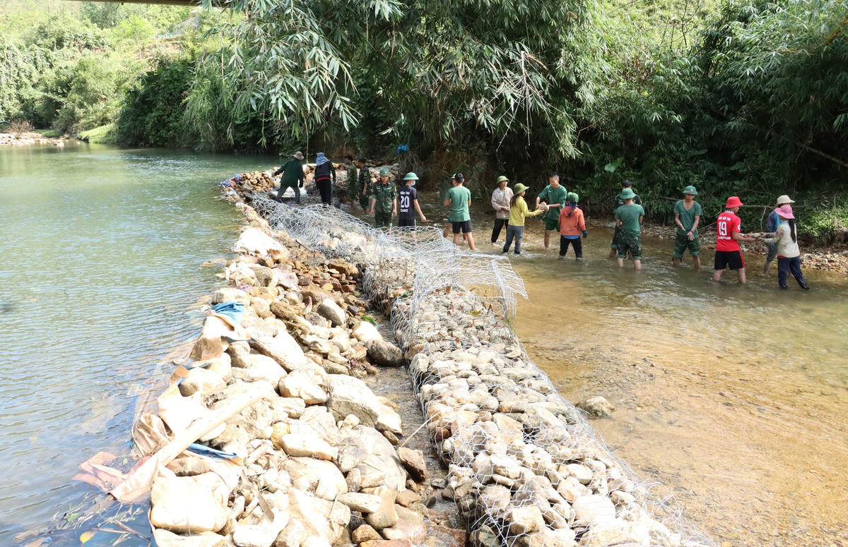Cán bộ, chiến sĩ Trung đoàn 6 giúp người dân xã A Roàng ngăn đập phục vụ cho việc trồng lúa nước.