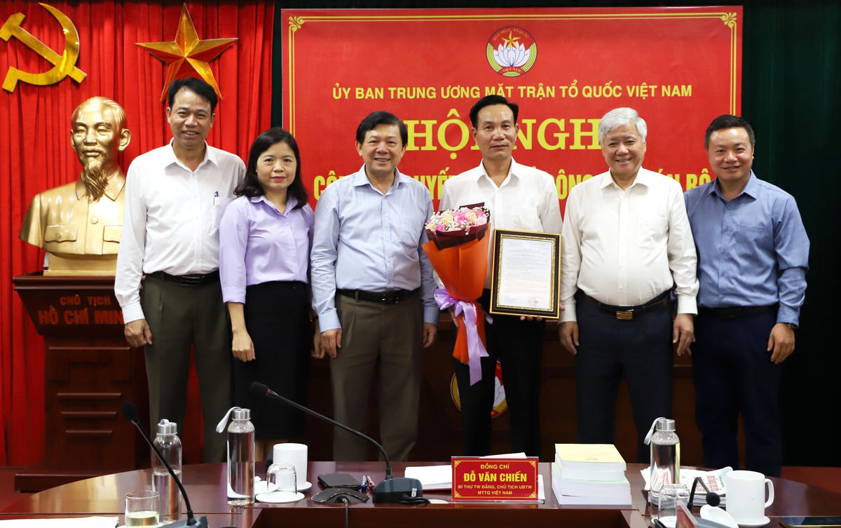 Chủ tịch Đỗ Văn Chiến, Phó Chủ tịch Nguyễn Hữu Dũng tặng hoa chúc mừng tân Phó Giám đốc Trung tâm Bồi dưỡng cán bộ và Nghiên cứu khoa học MTTQ Việt Nam Nguyễn Minh Phú.
