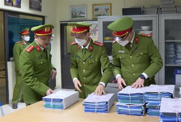 Công an niêm phong, thu giữ hồ sơ, tài liệu tại một trung tâm đăng kiểm ở Hà Nội. Nguồn: TTXVN.  