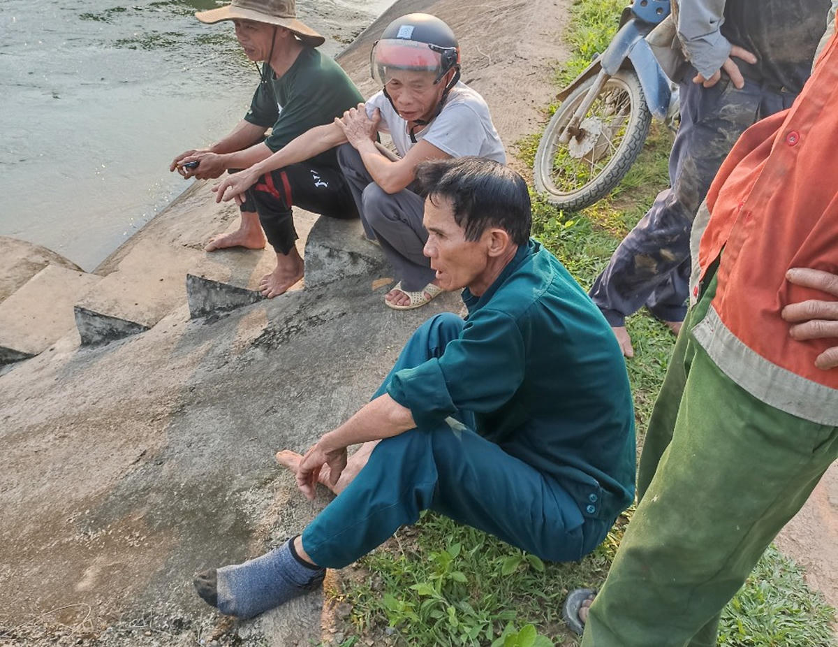 Ông Huệ (áo xanh) khá mệt sau khi cứu được hai nạn nhân (Ảnh: T.T.).