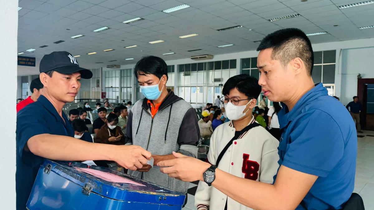 Người dân lấy số thứ tự để mua vé.