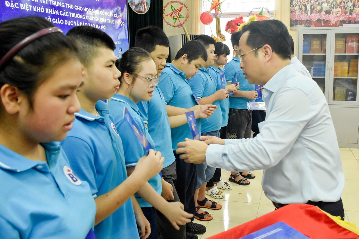 Giám đốc Sở GDĐT Hà Nội trao quà cho các em học sinh có hoàn cảnh đặc biệt khó khăn.