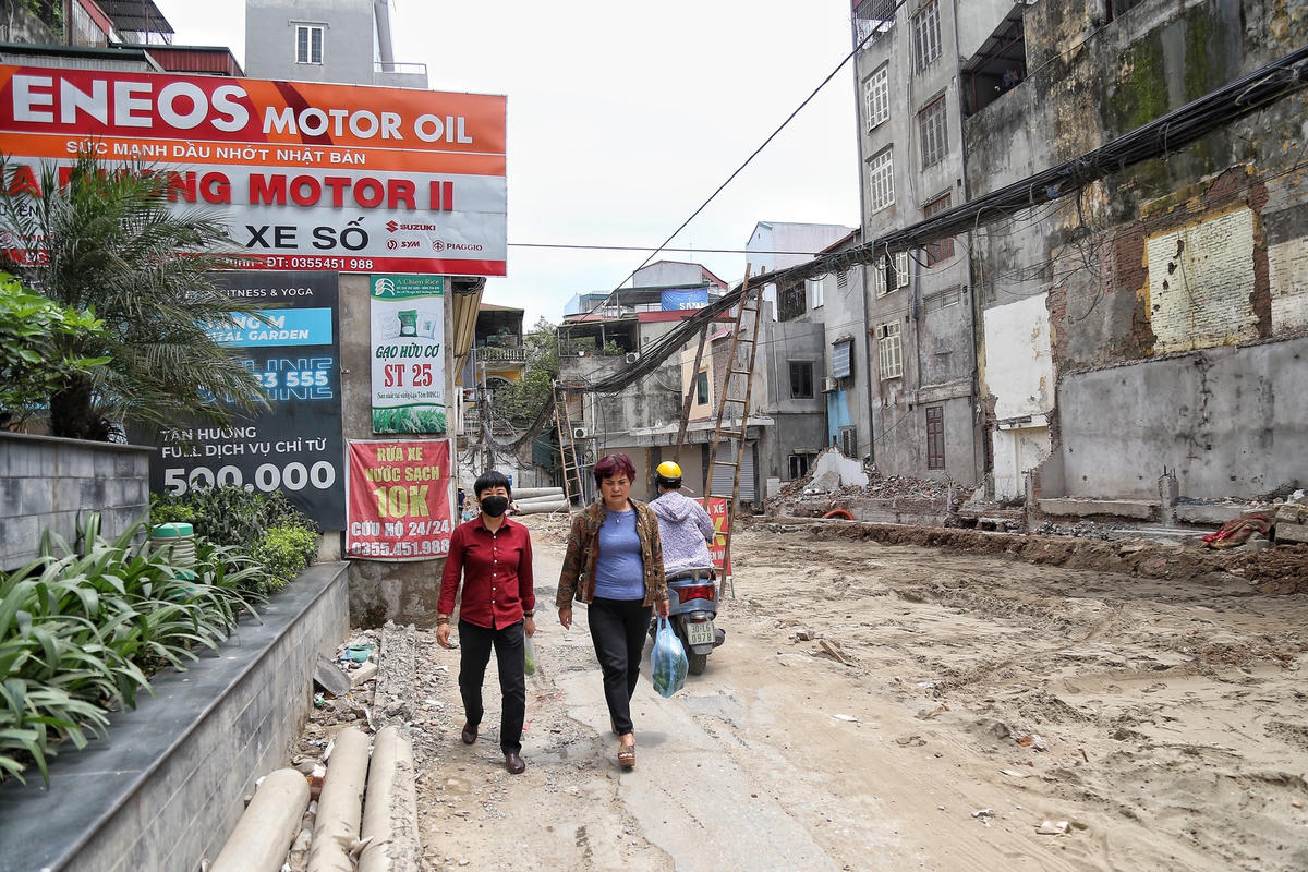 Một số người dân tại ngõ 102 Trường Chinh cho hay, trước đây, dây điện được cố định trên cao, sát tường nhà dân. Nhưng từ khi có dự án giải tỏa một số hộ dân thì dây diện không có điểm tựa cố định nên võng xuống thấp, chủ đầu tư phải dùng thang chống lên để người dân đi lại thuận tiện hơn.