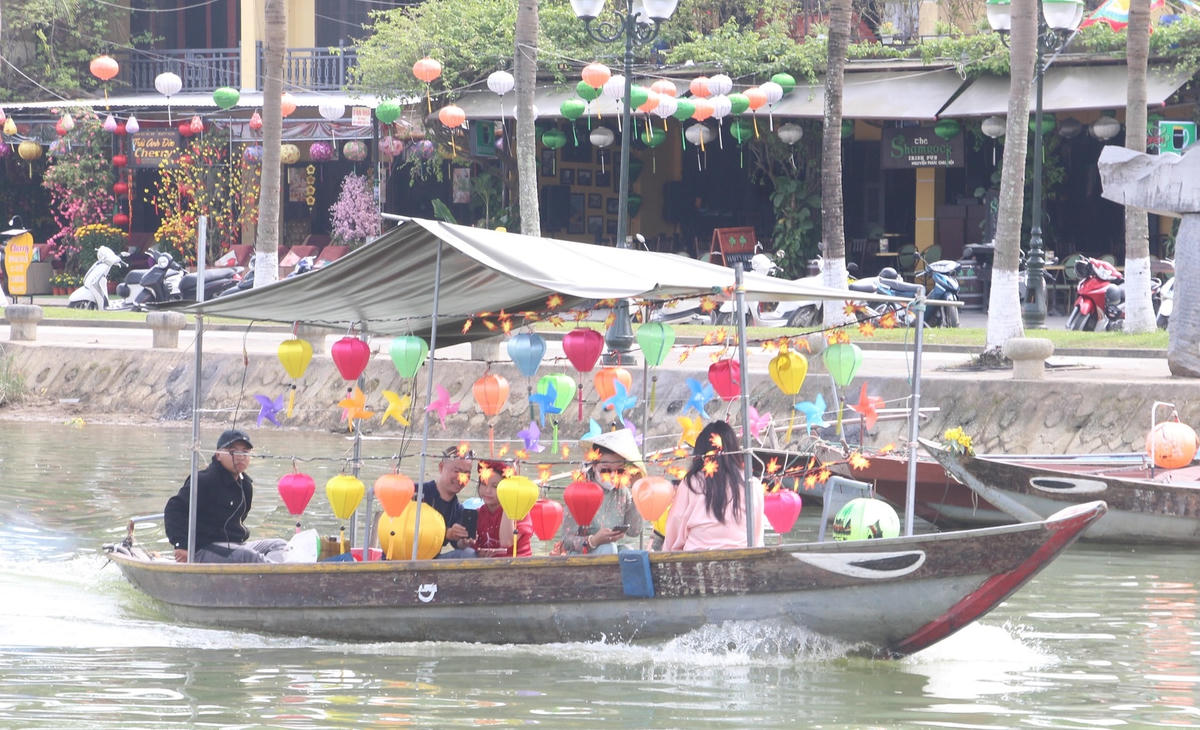 Du khách đi thuyền ngắm nhìn phố cổ Hội An.