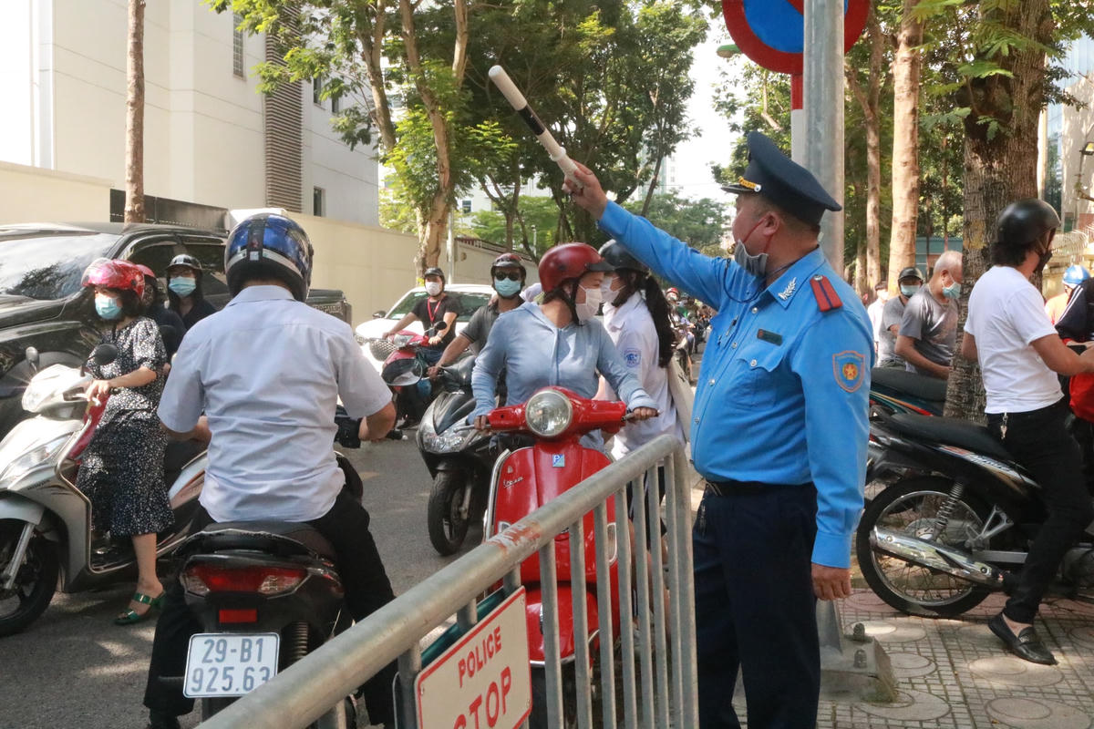 Lực lượng chức năng nhắc nhở người dân, tránh ùn tắc giao thông tại điểm thi Trường THCS Thăng Long.