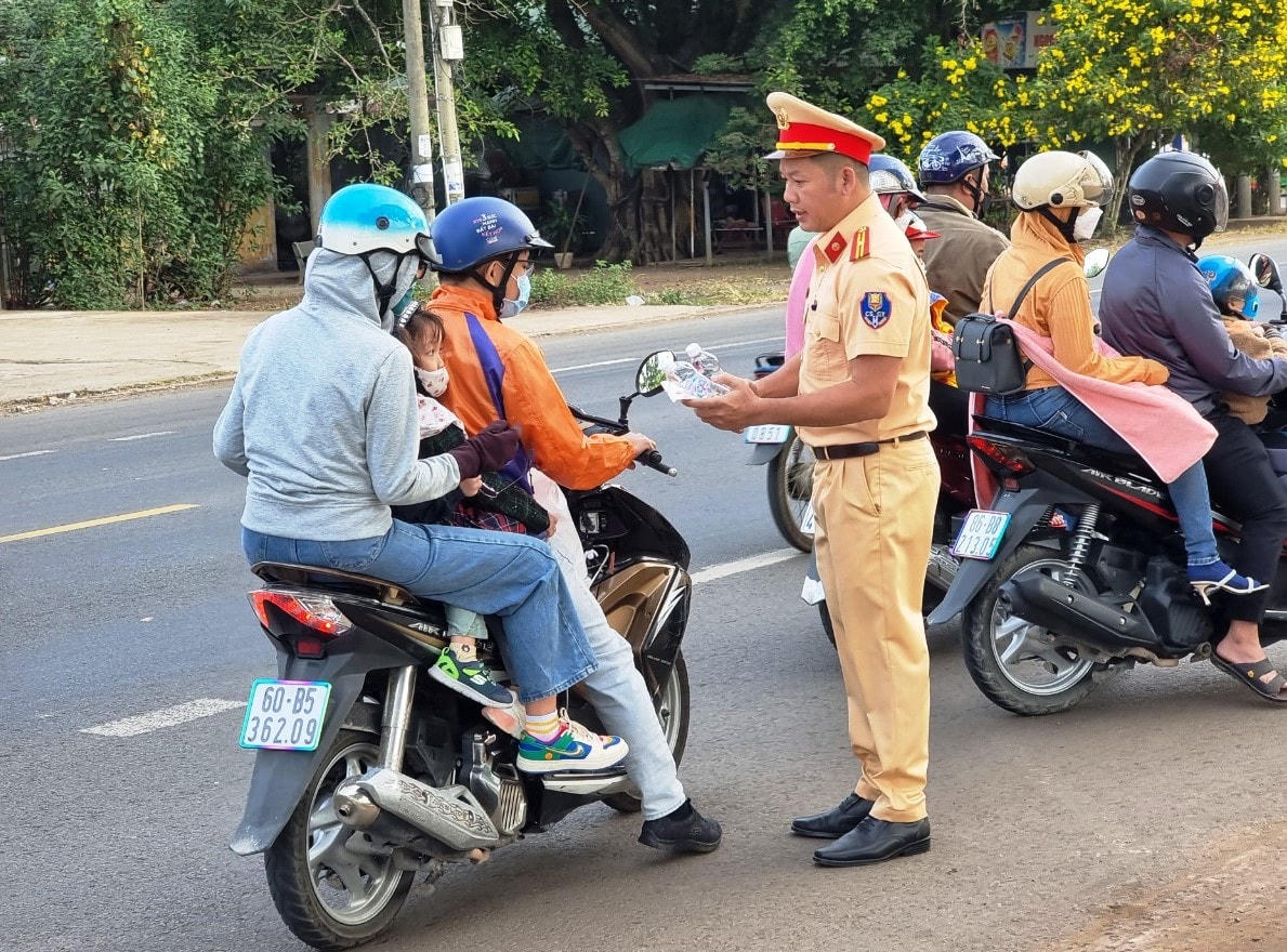 Cán bộ, chiến sĩ Đội CSGT số 2 – Phòng CSGT Công an tỉnh Đồng tặng khăn lạnh và nước miễn phí cho người dân trên đường về quê đón Tết khi đi qua Quốc lộ 20.