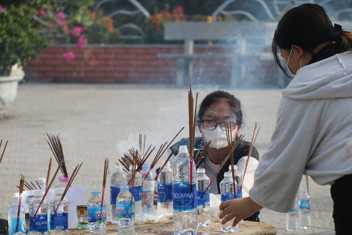 Trước khi đến đây, các sĩ tử mang theo hương và chai nước đặt dưới nền trước tượng Phật để cầu nguyện. 