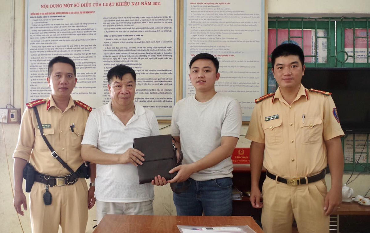 Anh Mai Trung Hiếu cùng lực lượng CSGT trả lại tài sản cho người đánh rơi.