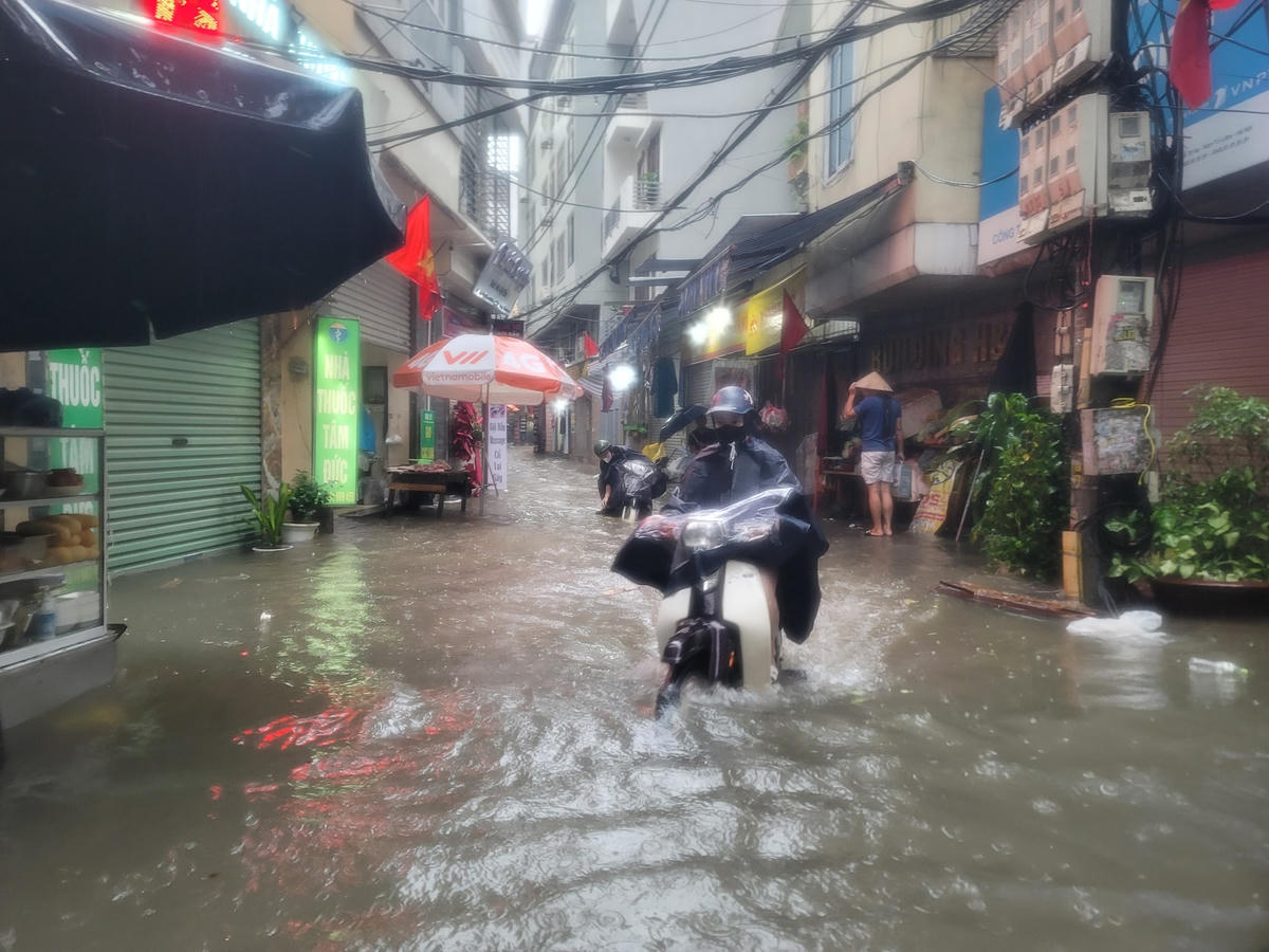 Hà Nội nhiều khu vực ngập trắng đường, người dân vất vả dắt xe, lội nước