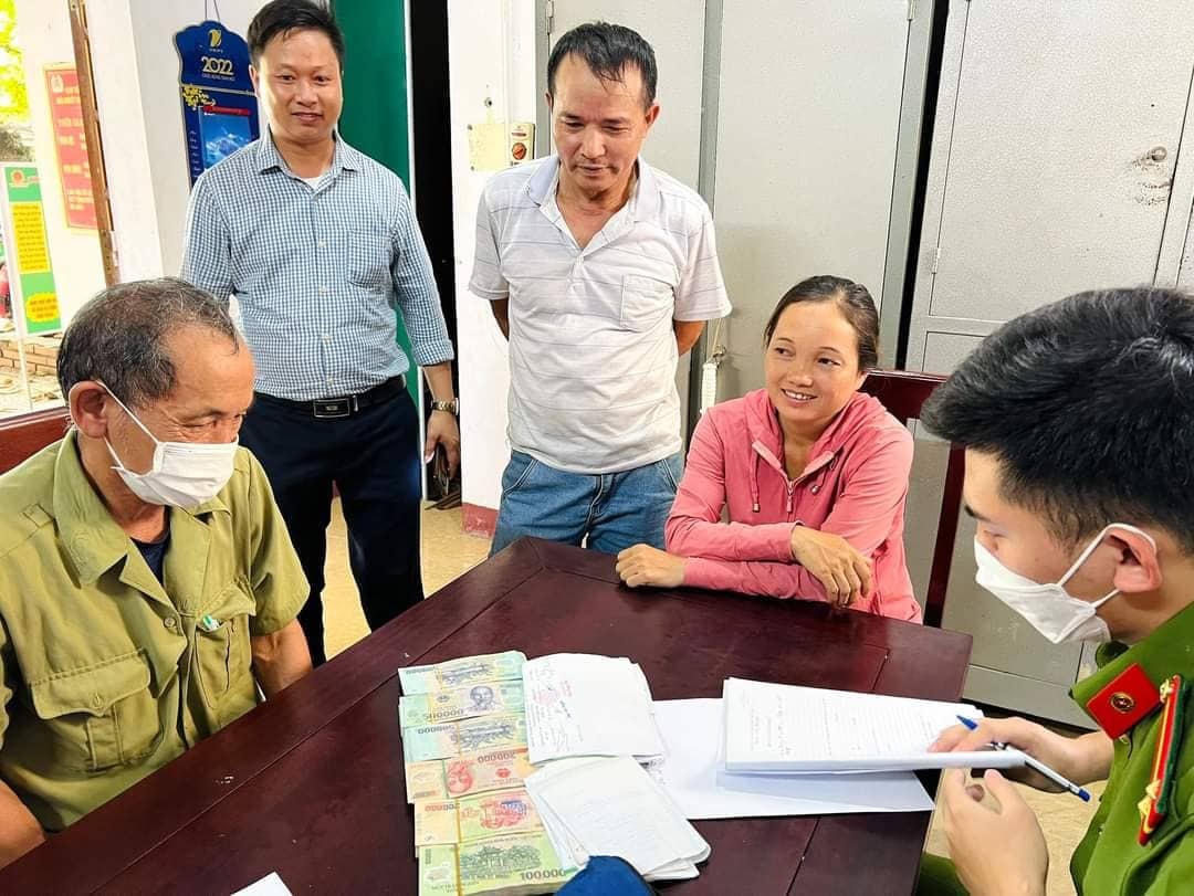 Vợ chồng anh Ngọc, chị Xuân cùng Công an xã Thanh Giang kiểm đếm số tiền để trả lại cho ông Bình - người đánh rơi số tiền hơn 200 triệu đồng.