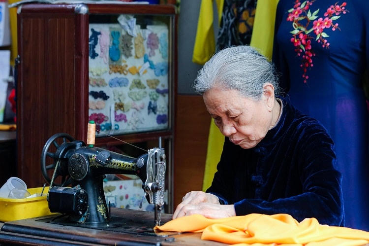 Nghệ nhân Lê Thị Quyến bên bàn may.  