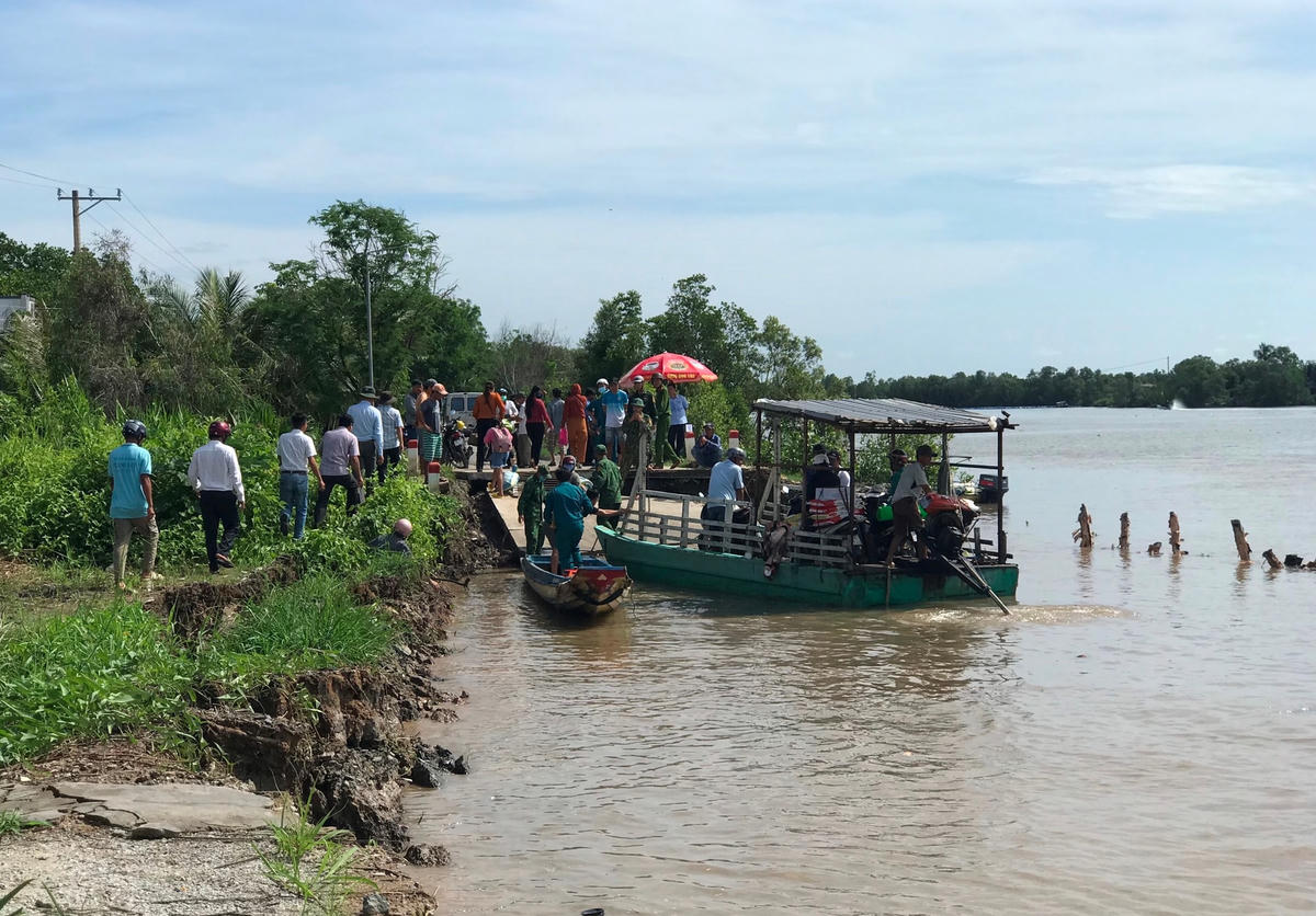 Do đường bị sạt lở, chính quyền địa phương huy động phà đưa, rước xe mô tô qua khu vực sạt lở.