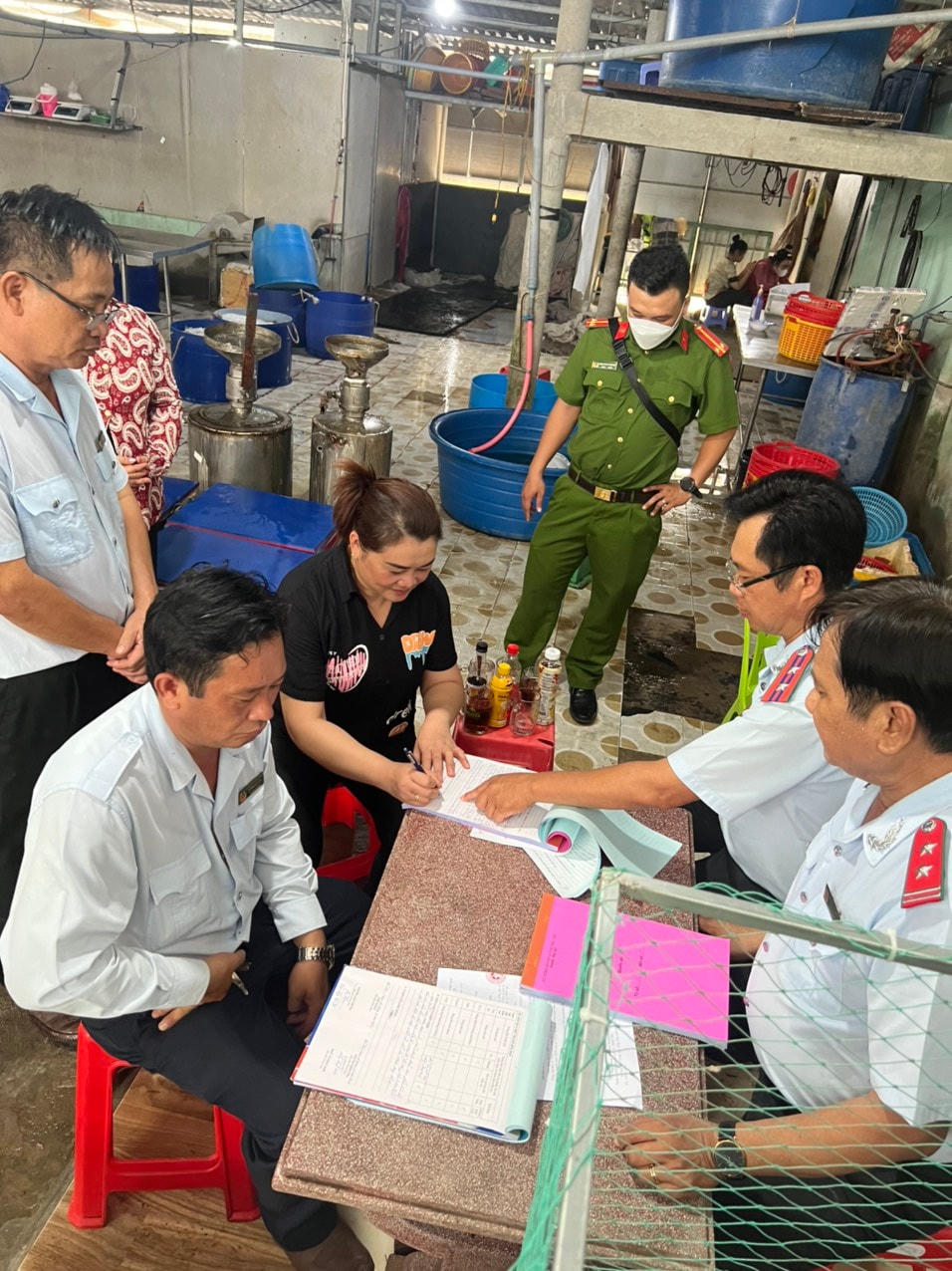 Lực lượng chức năng tiến hành lập biên bản vi phạm hành chính đối với chủ cơ sở bơm tạp chất vào tôm sú.