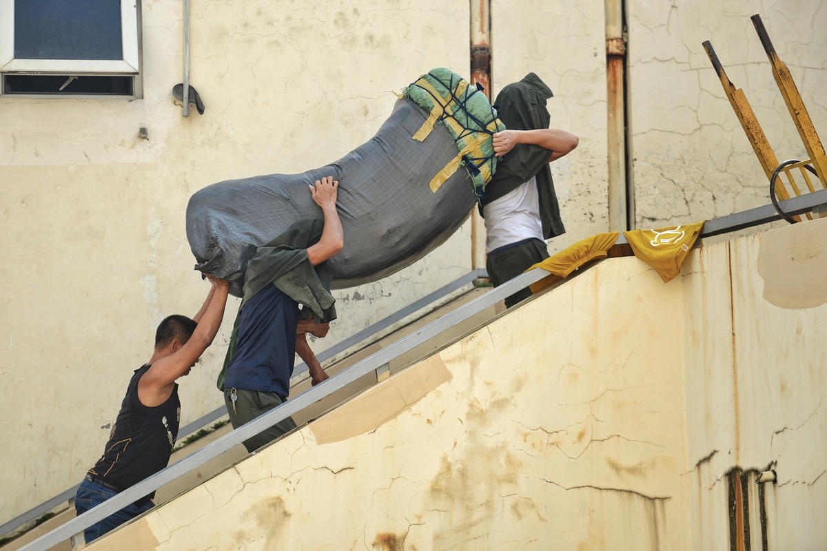 Sau khi vận chuyển hàng lên tầng 2, do những bao tải có trọng lượng khá nặng những “cửu vạn” lại hỗ trợ nhau bên lên tầng 3.  