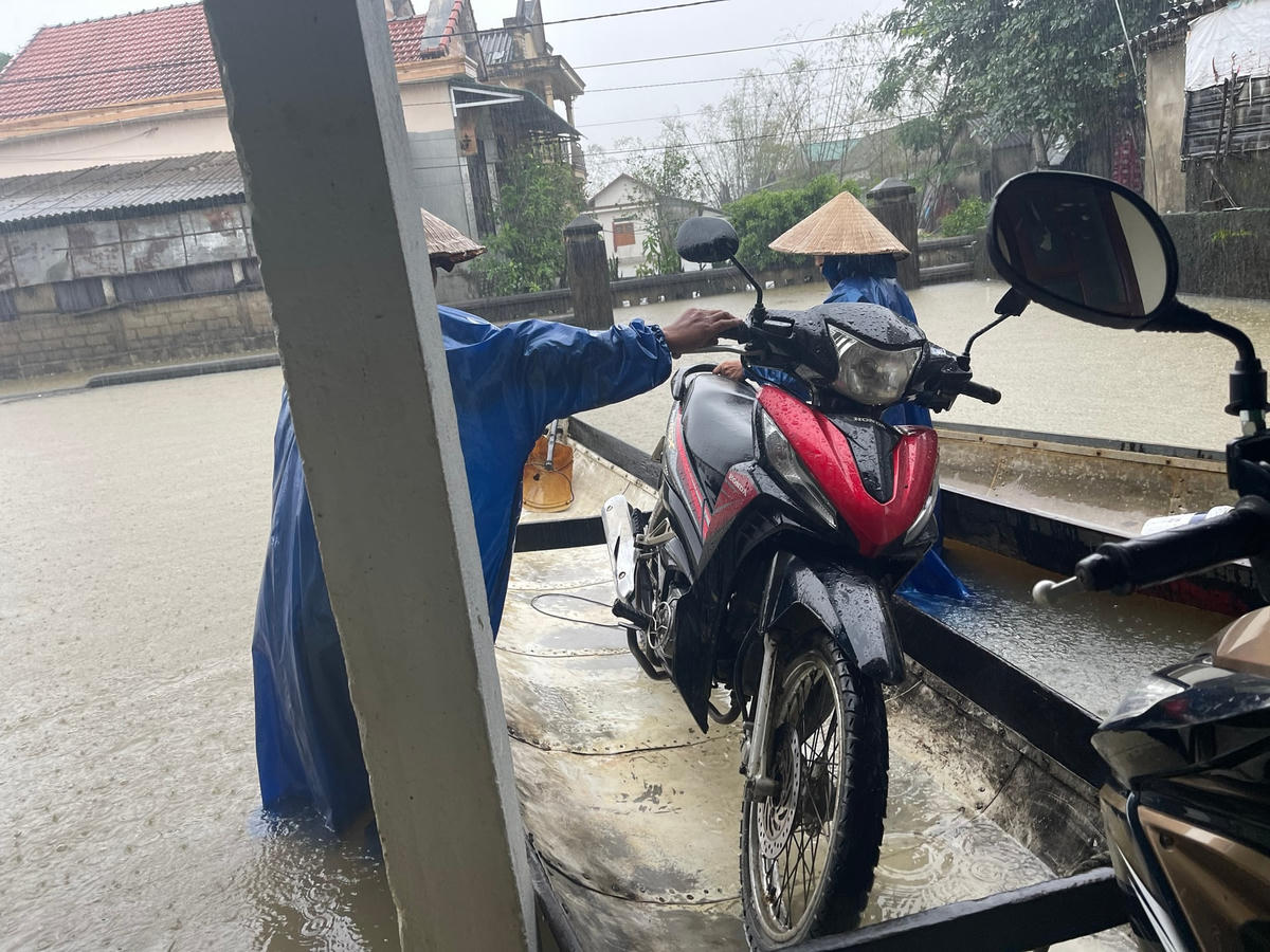 Người dân dùng ghe để chở đồ đạc, xe máy đưa đến nơi cao hơn. Ảnh: CTV.  