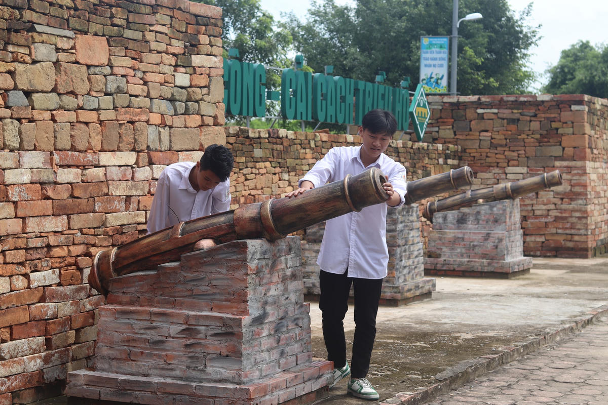 Tại đây, đoàn được hướng dẫn viên mô tả cách sử dụng súng thần công và quá trình quân đội triều Hồ kháng chiến chống quân Minh xâm lược. Ảnh: Đình Minh 