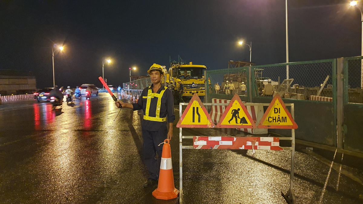 Công nhân phân luồng giao thông trước giờ vận chuyển phiến dầm.