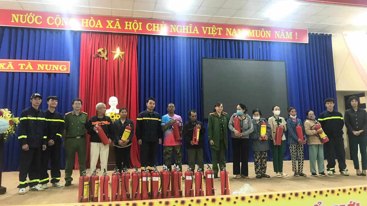 Lực lượng Công an và lãnh đạo xã Tà Nung trao bình chữa cháy xách tay cho các hộ đồng bào DTTS xã Tà Nung.