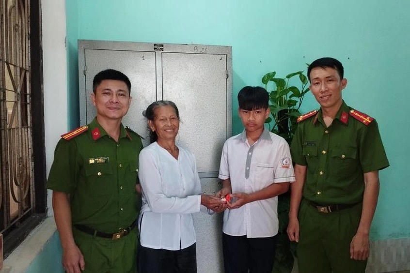 Em Quân trao trả nhẫn vàng cho người đánh rơi trước sự chứng kiến của  công an. Nguồn: Dân Trí.