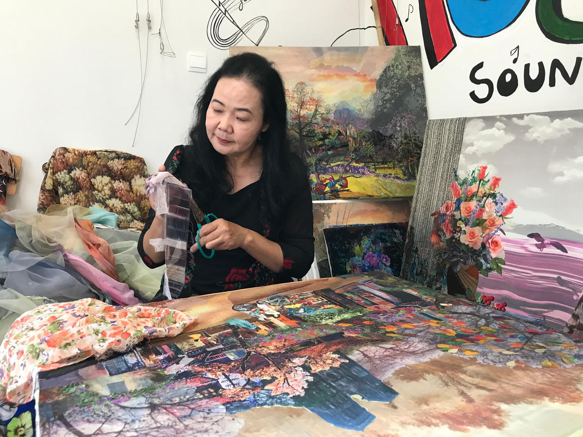 Họa sĩ Trần Thanh Thục bên tác phẩm.  