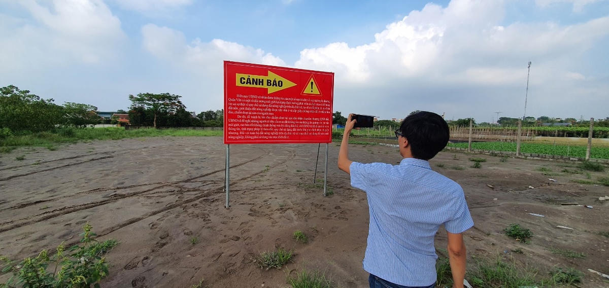 Phóng viên Báo Đại Đoàn Kết tại khu đất mà Bank Land rao là dự án được phân lô bán nền, nay đã được UBND xã Hồng Vân dựng biển cảnh báo người dân. 