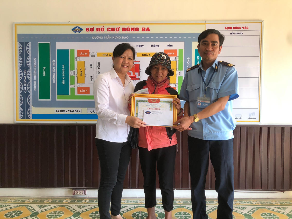 Đại diện BQL chợ Đông Ba tặng giấy khen cho chị Trần Thị Thu Hà vì có hành động đẹp.