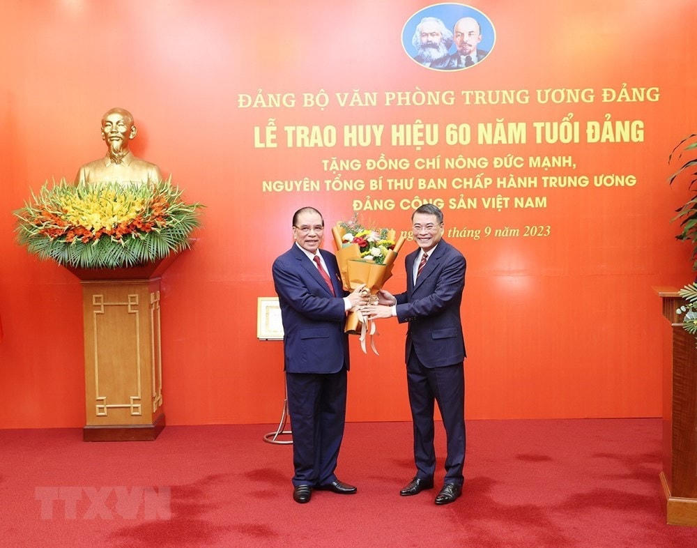 Đồng chí Lê Minh Hưng, Bí thư Trung ương Đảng, Chánh Văn phòng Trung ương Đảng, chúc mừng nguyên Tổng Bí thư Nông Đức Mạnh. (Ảnh: Trí Dũng/TTXVN).