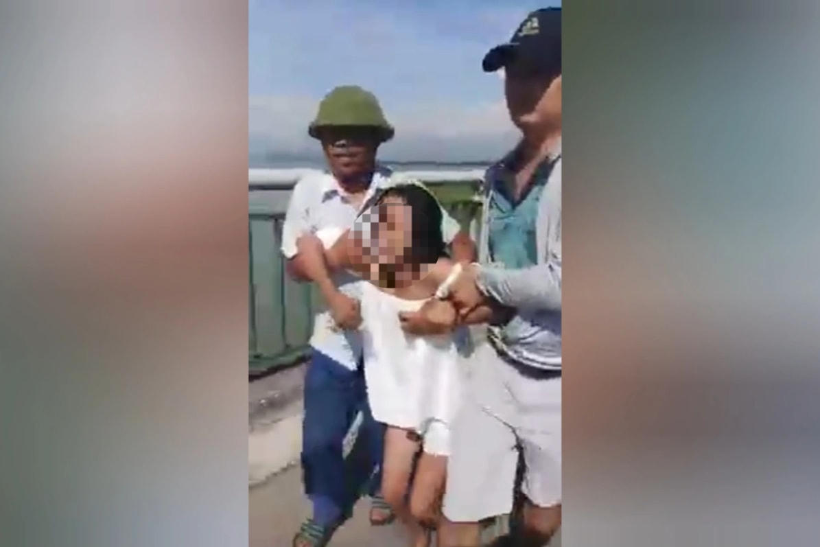 Hai người đàn ông cứu cô gái có ý định nhảy cầu Bến Thủy 2. (Ảnh cắt từ clip).