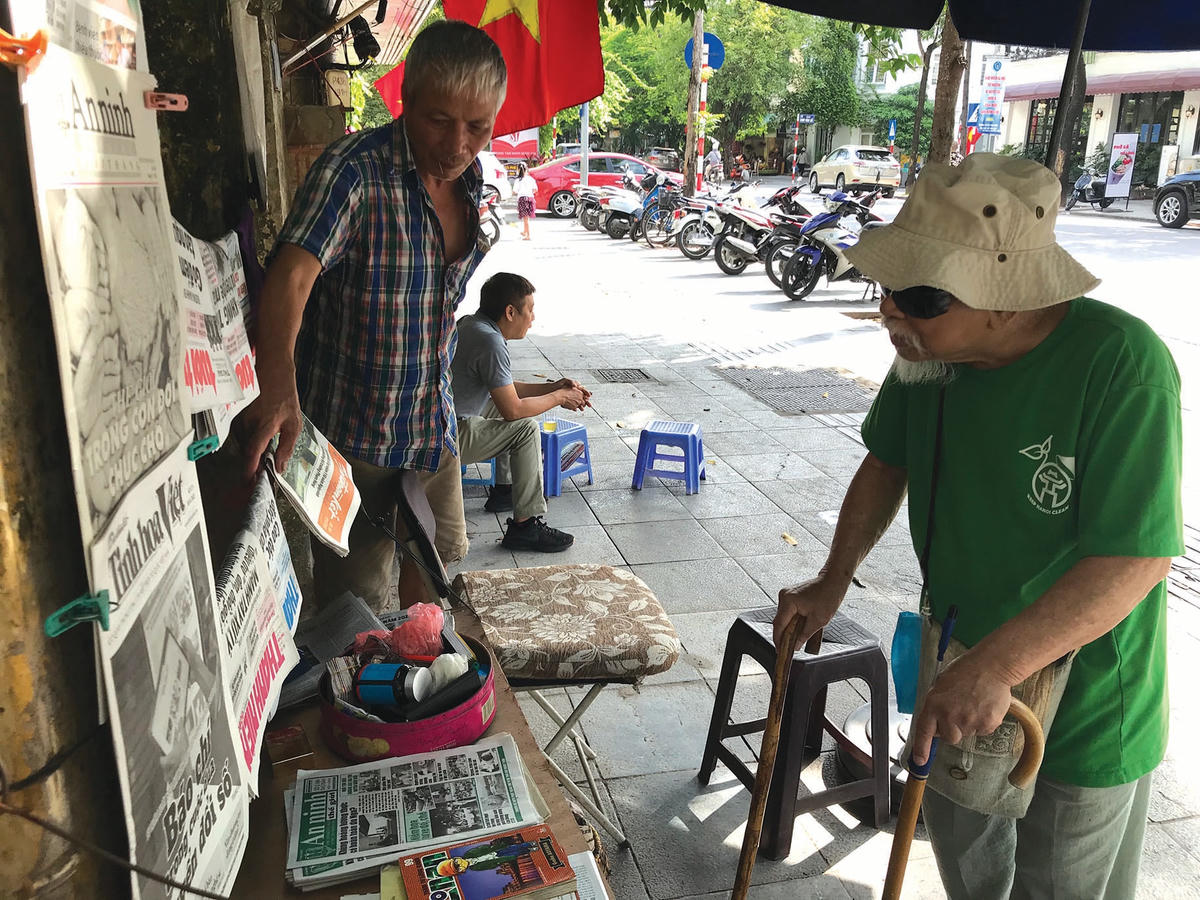 Độc giả cao tuổi mua báo tại sạp báo ở số 30 phố Quang Trung.  