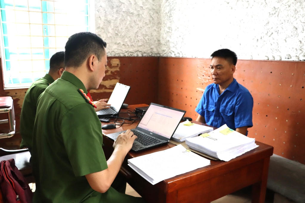 Điều tra viên lấy lời khai đối tượng Nguyễn Mạnh Hải. Ảnh: Hà Tâm.