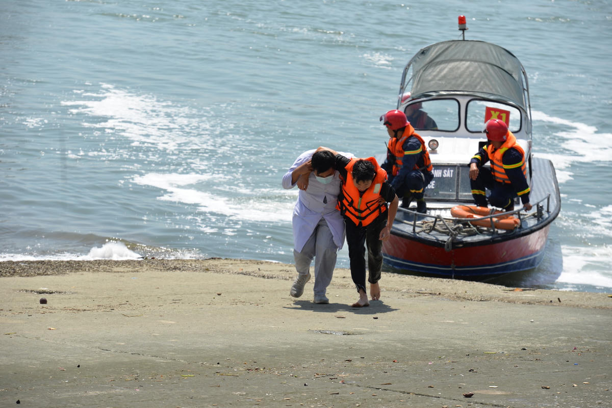 Lực lượng y tế hỗ trợ người gặp nạn lên bờ.