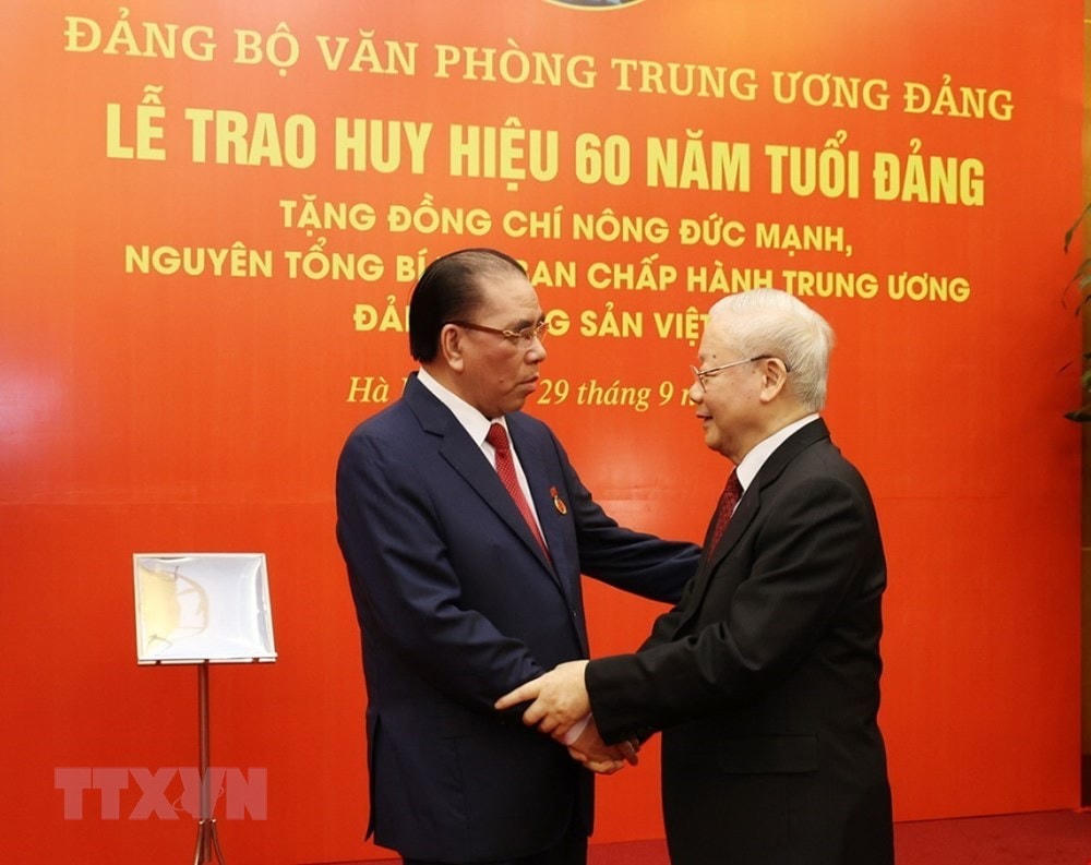 Tổng Bí thư Nguyễn Phú Trọng chúc mừng nguyên Tổng Bí thư Nông Đức Mạnh. (Ảnh: Trí Dũng/TTXVN).